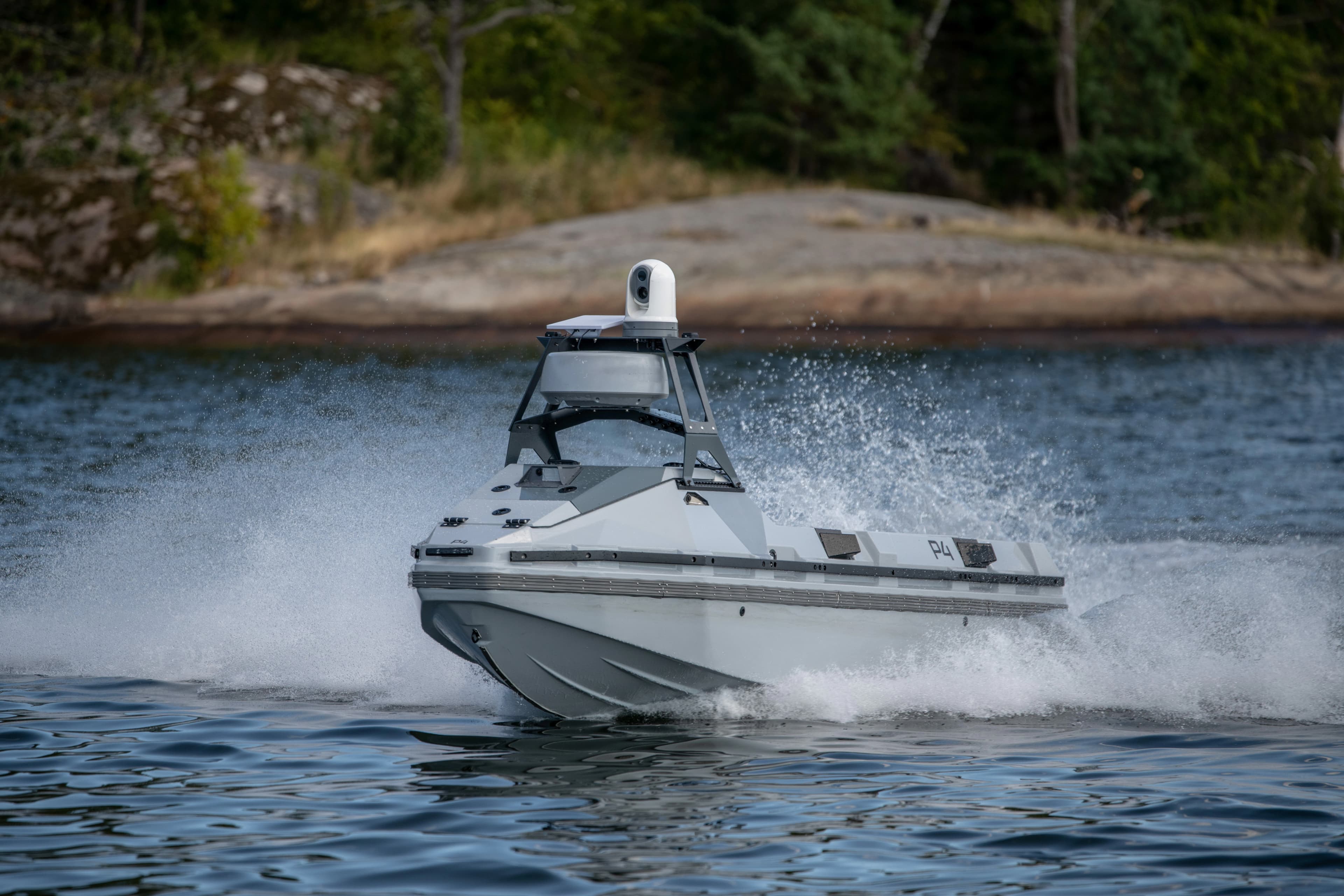 Nautrik R4 vessel planing past a rocky shoreline